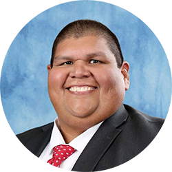 Alfredo Andrade wearing a suit and smiling