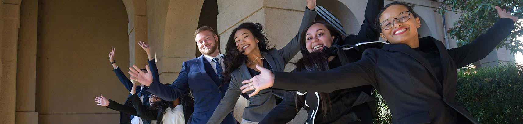 Grad business students jumping