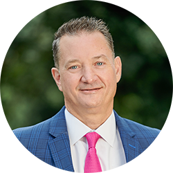 Rod McDermott wearing a suit and smiling