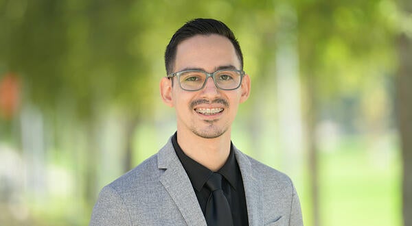 Dynami Martinez wearing a suit and smiling