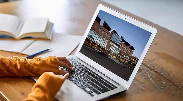 Online MBA student typing on laptop