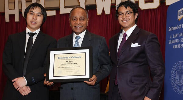 Professor Raj Singh and two UCR Business students, receiving an award