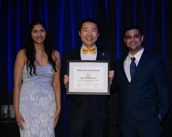Ye Li at the Golden Apple award ceremony holding his award certificate.