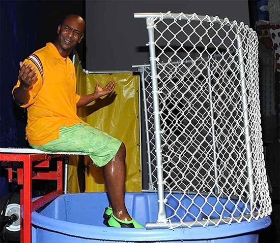 Former BET executive Stephen Hill sits above a dunk tank for a fundraiser